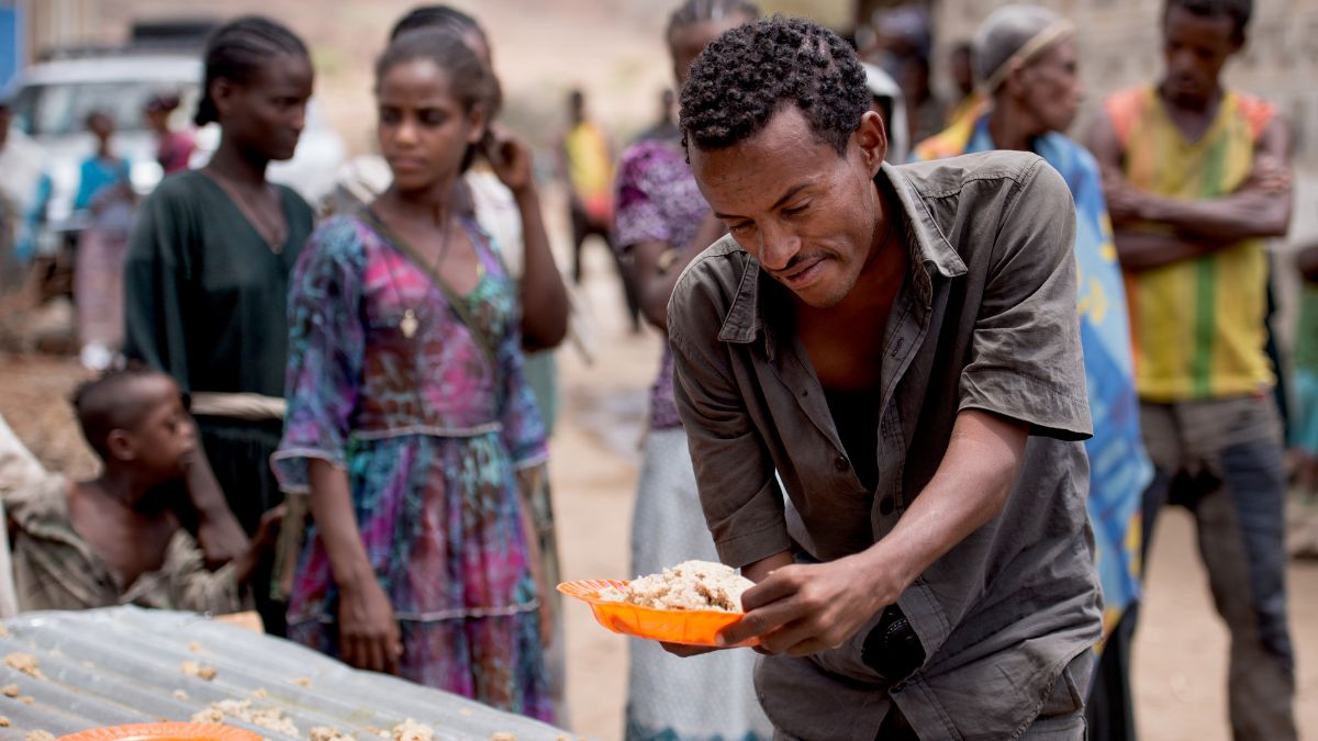 A community member with a physical impairment is allowed to eat at Tartuarwa Primary School in the East Belessa district of Ethiopia on May 17, 2016. Students and other community members with disabilities receive a daily meal and water through a school feeding and water distribution program funded by CBM.