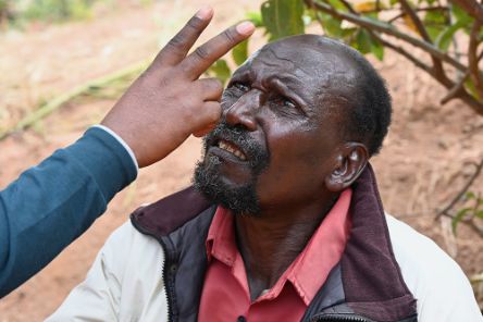 Ein Mann schaut mit gerunzelter Stirn auf die zwei Finger, die ihm jemand vors Gesicht hält.