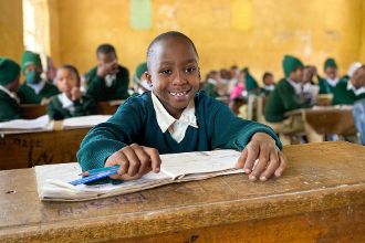 Junge am Schulpult im Klassenzimmer