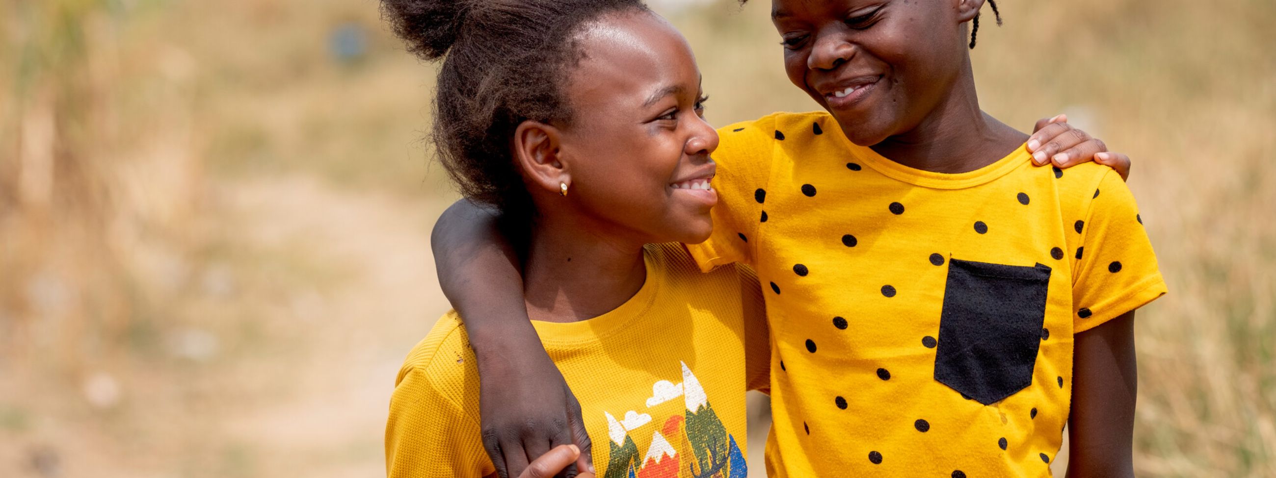 Two girls wearing yellow walking together 
