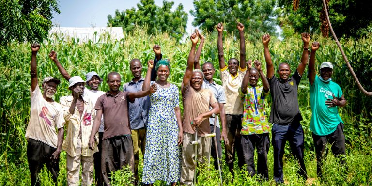 A group of farmers in front of a maize field 