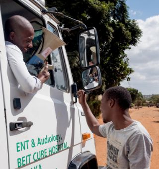 African man with megaphone looking out of the car window