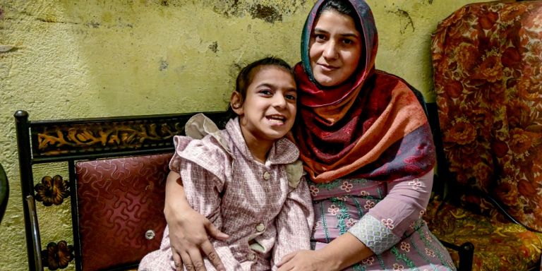 A mother and her intellectual and physical disabled daughter sitting on a bench