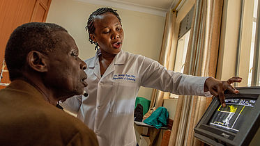 A female doctor - Dr. Angela Birungi - explains her findings to a patient Kagwisagye John Bosco diagnosed with cataracts. They are in a diagnosis room at Mbarara University of Science and Technology in Uganda. 