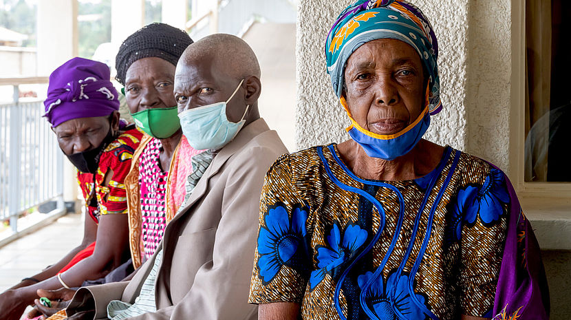 Three women and a man sitting in a waiting area. They live in Rwanda 