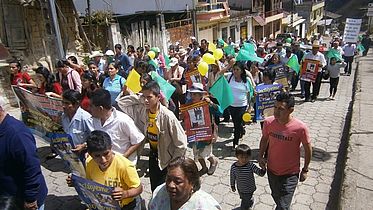 This photo shows a large group of people marching for their rights in the streets of Espindola.