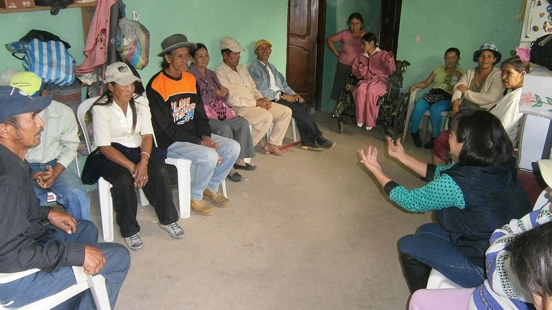 This photo shows a group of people sitting in a room discussing.