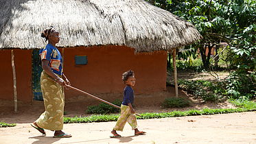 Therese, blind due to onchocerciasis, led by her grandchild. 