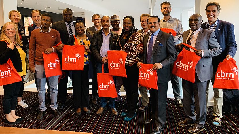 CBM staff attending the NNN gather for a group photo and show off bags with the CBM logo
