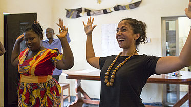 participants laugh and raise their hands during a mental health workshop