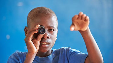 Boy using a telescope to see